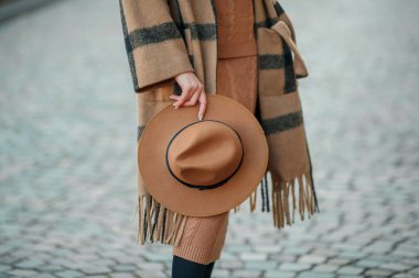 Bir Avrupa şehrinde şapkalı güzel genç bir kadın yürüyor.