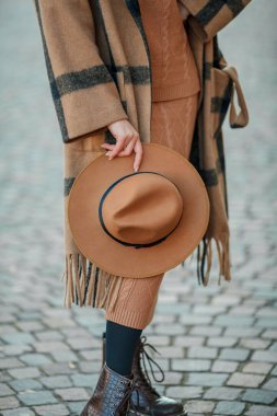 Bir Avrupa şehrinde şapkalı güzel genç bir kadın yürüyor.