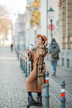 Kahveli şapkalı güzel genç bir kadın Avrupa 'da yürüyor.