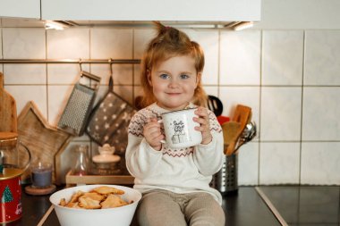 Küçük kız yıldız şeklinde kurabiyeler yiyor. Noel kurabiyeleri.