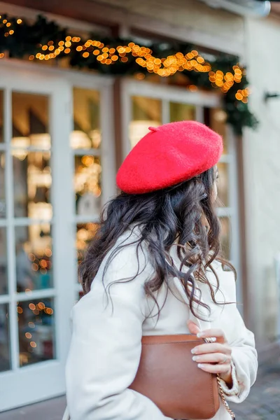 在欧洲的一个城市 一个年轻美丽的女人穿着红色贝雷帽的画像 年轻的女人拿着一个纸袋和面包 圣诞节 — 图库照片