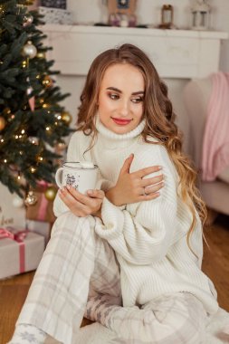 Noel ağacının yanında genç ve güzel bir kadın. Tatiller.