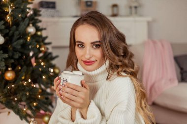 Noel ağacının yanında genç ve güzel bir kadın. Tatiller.