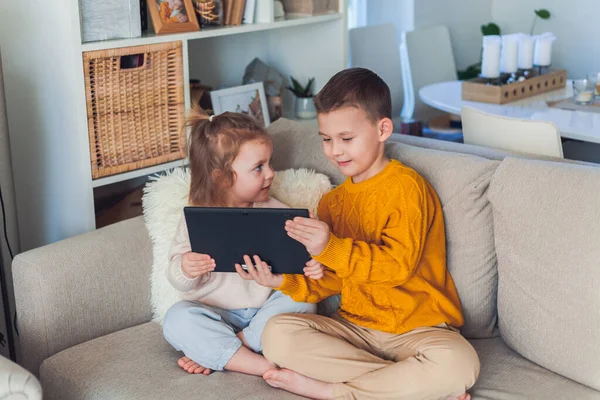 Leuke kinderen praten per videogesprek met een tablet. Quarantaine. Een gezin. — Stockfoto