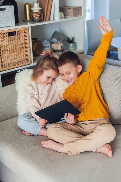 Leuke kinderen praten per videogesprek met een tablet. Quarantaine. Een gezin. — Stockfoto