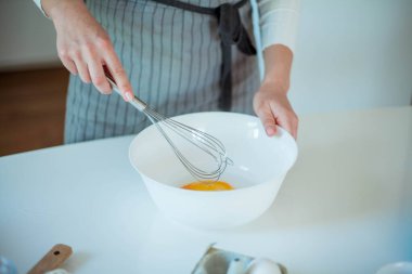 Genç ve güzel bir kadın kek pişiriyor. Tatlılar.