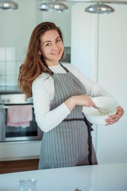 Genç ve güzel bir kadın kek pişiriyor. Tatlılar.
