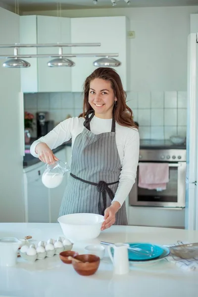 Young beautiful woman bakes a cake. Sweets.