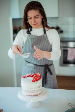 Genç ve güzel bir kadın kek pişiriyor. Şekerler. Şekerlemeci.