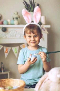Paskalya. Küçük bir çocuk Paskalya yumurtalarını boyuyor. Paskalya dekoru.