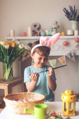 Paskalya. Küçük bir çocuk Paskalya yumurtalarını boyuyor. Paskalya dekoru.