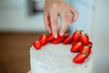 Genç ve güzel bir kadın kek pişiriyor. Tatlılar.