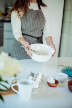 Genç ve güzel bir kadın kek pişiriyor. Tatlılar.