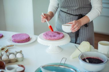 Genç ve güzel bir kadın kek pişiriyor. Tatlılar.