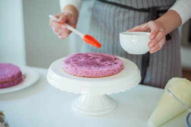 Genç ve güzel bir kadın kek pişiriyor. Tatlılar.