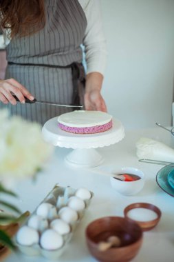 Genç ve güzel bir kadın kek pişiriyor. Tatlılar.