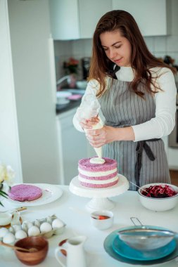 Genç ve güzel bir kadın kek pişiriyor. Tatlılar.
