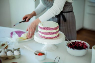 Genç ve güzel bir kadın kek pişiriyor. Tatlılar.