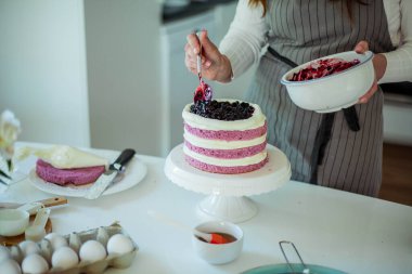 Genç ve güzel bir kadın kek pişiriyor. Tatlılar.