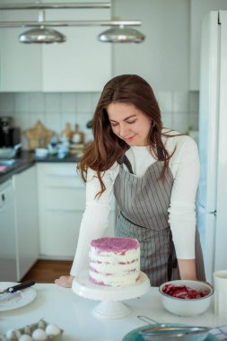 Genç ve güzel bir kadın kek pişiriyor. Tatlılar.
