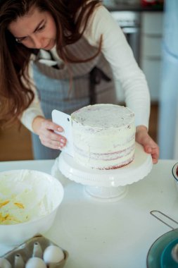 Genç ve güzel bir kadın kek pişiriyor. Tatlılar.