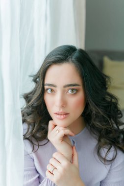 Leylak elbiseli güzel, kıvırcık bir kadının yakın portresi. Bahar. Moda. Samimi.