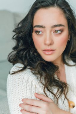 Genç, güzel, kıvırcık bir kadının güzel, rahat ev portresini kapat. Bahar. Moda..