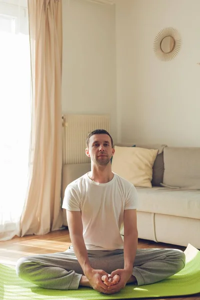 Young man doing yoga. Online classes at home.