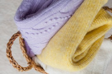 Bir yığın örgü süveter. Bahar için kıyafetler. Renkler, sarı, leylak. Samimi.