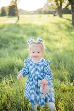 Çiçek açan bir bahçede piknikte dinlenen güzel küçük kız. Beyaz çiçekler. Bahar.