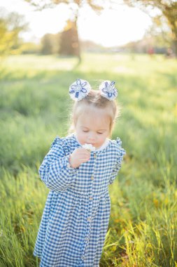 Çiçek açan bir bahçede piknikte dinlenen güzel küçük kız. Beyaz çiçekler. Bahar.