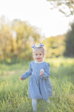 Çiçek açan bir bahçede piknikte dinlenen güzel küçük kız. Beyaz çiçekler. Bahar.