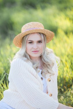 Güzel genç bir kadın çiçek açan bir bahçede piknikte dinleniyor. Beyaz çiçekler. Bahar.