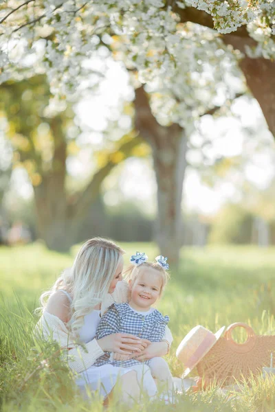 Piękna Młoda Matka Córeczką Odpoczywają Pikniku Kwitnącym Ogrodzie Białe Kwiaty — Zdjęcie stockowe