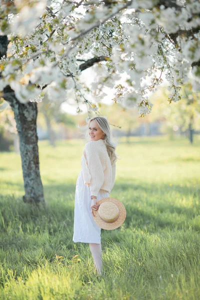 美丽的年轻女子正在一个盛开的花园里野餐 白色的花春天 — 图库照片
