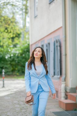 Mavi takım elbiseli, bir buket lale taşıyan güzel bir genç kadının portresi..