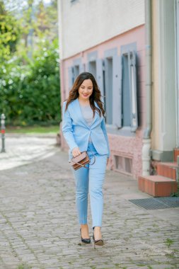 Mavi takım elbiseli, bir buket lale taşıyan güzel bir genç kadının portresi..