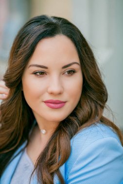 Mavi takım elbiseli, bir buket lale taşıyan güzel bir genç kadının portresi..