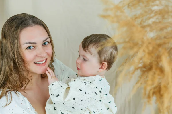 Krásná Mladá Matka Modrýma Očima Malé Dcery Béžovém Pozadí — Stock fotografie