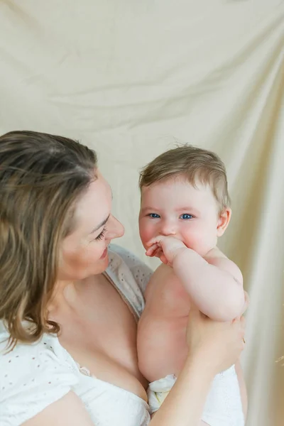 Schöne Junge Mutter Mit Blauäugiger Kleiner Tochter Auf Beigem Hintergrund — Stockfoto