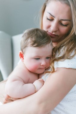 Mavi gözlü küçük kızı olan güzel bir anne evde dinleniyor..