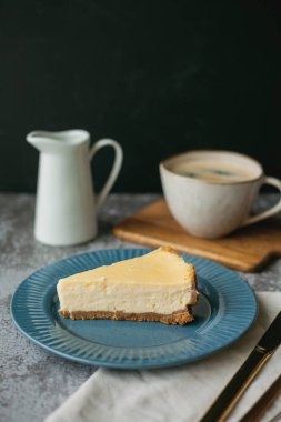 Fırın ürünleri. Bir parça ev yapımı peynirli kek ve bir kupa kahve..