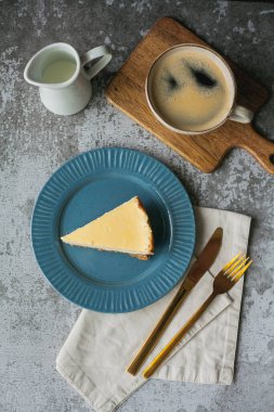 Fırın ürünleri. Bir parça ev yapımı peynirli kek ve bir kupa kahve..