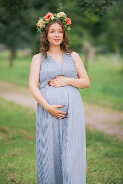 在公园里 一个头戴花环的年轻孕妇的画像 怀孕情况 — 图库照片
