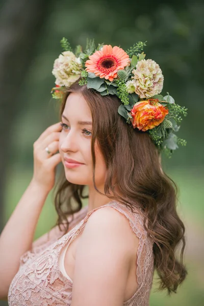 公園で彼女の頭に花輪を持つ若い妊婦の肖像画 — ストック写真