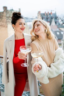 Şenlikli elbiseli ve ellerinde şampanya kadehleriyle iki genç kadın yeni yılı ve Noel 'i kutluyor. Tatiller.