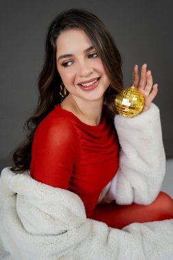 Yeni yıl konsepti. Altın disko toplu, şenlikli kıyafetli genç bir kadının portresi. Noel.