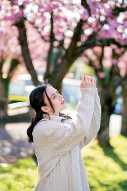 Çiçek açan bir bahçede genç bir kadının bahar portresi. Hayatın zevki. Meditasyon.