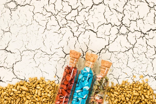 Crujido de frascos con piedras y granos de oro sobre fondo —  Fotos de Stock