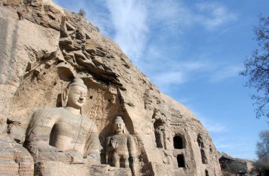 Çin 'in Shanxi eyaletindeki Datong yakınlarında Yungang Grottoes. Mağara 20, Yungang 'daki en ünlü Buda heykelleri. Gökyüzü ile geniş görüş açısı. Yungang Budist mağara sanatı ve heykelleri UNESCO dünya mirası